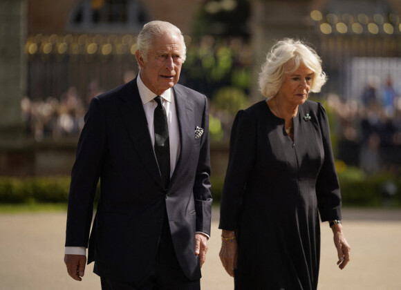 Le roi Charles III d'Angleterre et la reine consort Camilla Parker Bowles marchent le long des fleurs déposées en hommage à la reine Elisaberh II d'Angleterre, décédée le 8 septembre, devant le château de Hillsborough. Le 13 septembre 2022