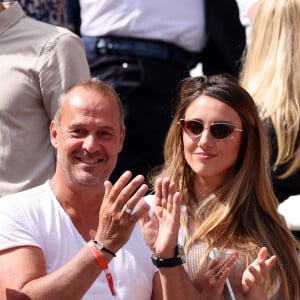 Roger Erhart et Delphine Wespiser, Miss France 2012 dans les tribunes des internationaux de France de Roland Garros à Paris le 31 mai 2022