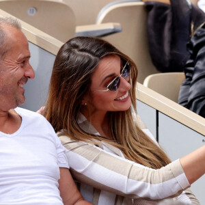 Roger Erhart et Delphine Wespiser, Miss France 2012 dans les tribunes des internationaux de France de Roland Garros à Paris le 31 mai 2022