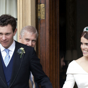 La princesse Eugénie et son mari Jack Brooksbank quittent le château de Windsor après leur mariage à bord d'une Aston Martin le 12 octobre 2018 sous le regard du père de la princesse Eugénie, le Duc d'York, le prince Andrew. 