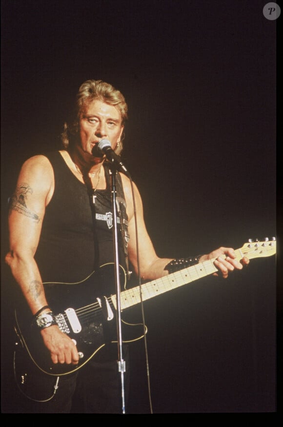 Johnny Hallyday en concert avec sa guitare.