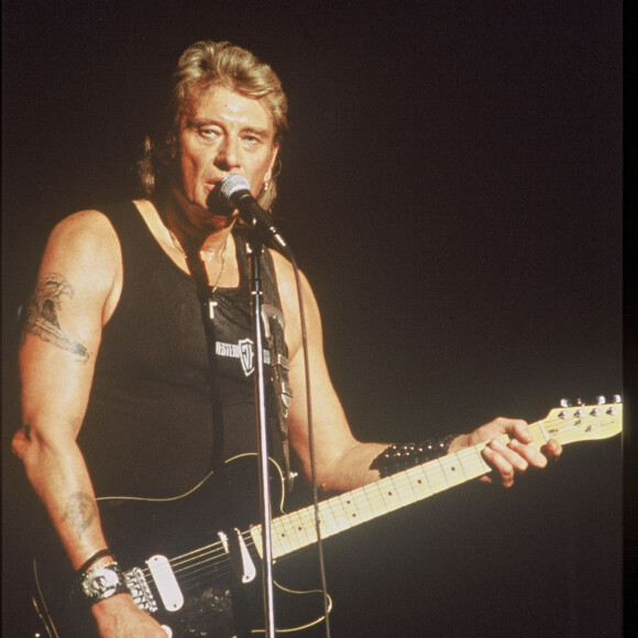 Johnny Hallyday en concert avec sa guitare.