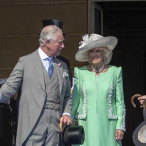 Camilla Parker Bowles, duchesse de Cornouailles, le prince Harry, duc de Sussex, et Meghan Markle, duchesse de Sussex, lors de la garden party pour les 70 ans du prince Charles au palais de Buckingham à Londres. Le 22 mai 2018 