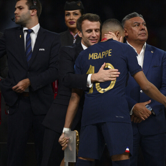 Kylian Mbappé accolade avec Emmanuel Macron - president de la Republique Francaise Noel Le Graet - president FFF - Remise du trophée de la Coupe du Monde 2022 au Qatar (FIFA World Cup Qatar 2022) à l'équipe d'argentine après sa victoire contre la France en finale (3-3 - tab 2-4). Doha, le 18 décembre 2022. 