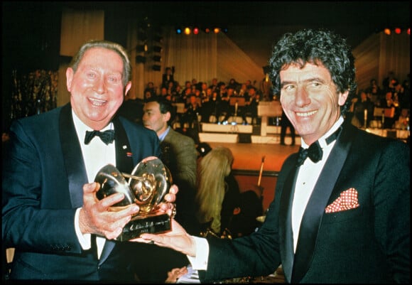Archives - Charles Trenet reçoit une victoire d'honneur des mains de Jack Lang, lors des Victoires de la musique. 1985.
