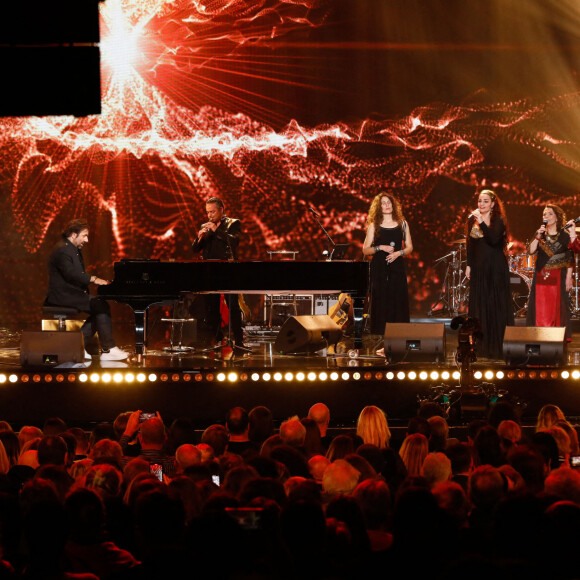 Exclusif - André Manoukian accompagne au piano quatre chanteuses des Balkans qui interprètent "L'ange à la fenêtre d'orient" lors de l'émission "Unis face au séisme" à l'Olympia diffusée en direct sur France 2 le 14 mars 2023. © Christophe Clovis/ Cyril Moreau / Bestimage 