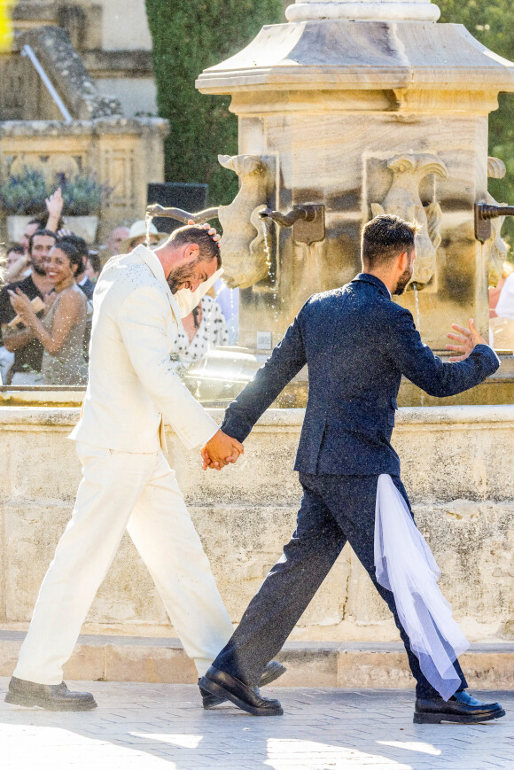 Une attache à ses racines, fondamentales pour lui : "J'ai eu des périodes où je me suis moins senti", confie-t-il. Ainsi, il s'autorise à prendre du temps pour lui et son couple. 
Simon Porte Jacquemus et son mari Marco Maestri - Mariage de Simon Porte Jacquemus et Marco Maestri à Charleval, France, le 27 août 2022. 