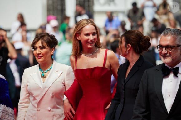 "Il n'y avait rien de politique là-dedans. Je n'avais aucune idée de ce qui était en train de se passer jusqu'à ce que ça sorte et que ça devienne une vraie polémique? Je savais que je serais lamentablement tombée si j'avais gardé mes chaussures."
Sahra Mani, Jennifer Lawrence, Justine Ciarrocchi - Montée des marches du film "Anatomie d'une chute" lors du 76e Festival de Cannes. Le 21 mai 2023. © Jacovides-Moreau / Bestimage