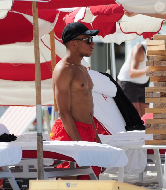 L'attaquant français du PSG Kylian Mbappé joue au Jenga (La Tour Infernale) lors d'une journée à la plage avec des amis à Miami, Floride, Etats-Unis, le 1er juillet 2023.