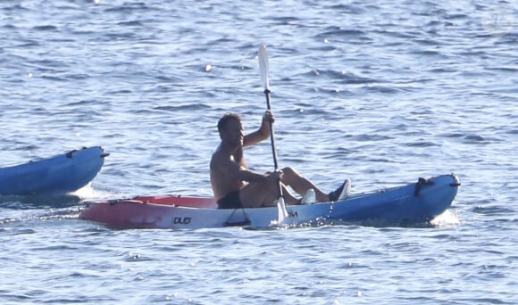 Exclusif - Le président Emmanuel Macron fait du canoë-kayak lors de ses vacances au Fort de Brégançon à Bormes-les-Mimosas le 3 aout 2022. Aux alentours de 18 heures, Emmanuel Macron a été aperçu seul, en maillot de bain noir et torse nu, sur un canoë bleu-blanc-rouge. Il s'est offert un court aller-retour d'une vingtaine de minutes, suivi par un agent de sécurité, lui aussi en canoë. © Luc Boutria/Nice-Matin/Bestimage 