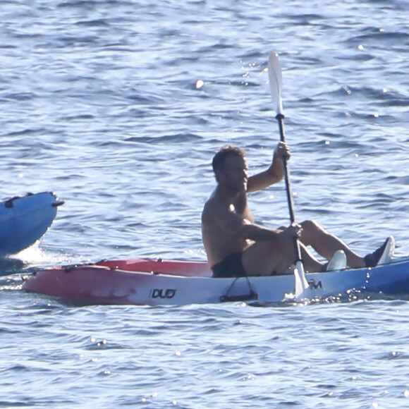 Exclusif - Le président Emmanuel Macron fait du canoë-kayak lors de ses vacances au Fort de Brégançon à Bormes-les-Mimosas le 3 aout 2022. Aux alentours de 18 heures, Emmanuel Macron a été aperçu seul, en maillot de bain noir et torse nu, sur un canoë bleu-blanc-rouge. Il s'est offert un court aller-retour d'une vingtaine de minutes, suivi par un agent de sécurité, lui aussi en canoë. © Luc Boutria/Nice-Matin/Bestimage 