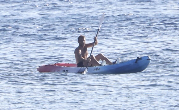 Exclusif - Le président Emmanuel Macron fait du canoë-kayak lors de ses vacances au Fort de Brégançon à Bormes-les-Mimosas le 3 aout 2022. Aux alentours de 18 heures, Emmanuel Macron a été aperçu seul, en maillot de bain noir et torse nu, sur un canoë bleu-blanc-rouge. Il s'est offert un court aller-retour d'une vingtaine de minutes, suivi par un agent de sécurité, lui aussi en canoë. © Luc Boutria/Nice-Matin/Bestimage 