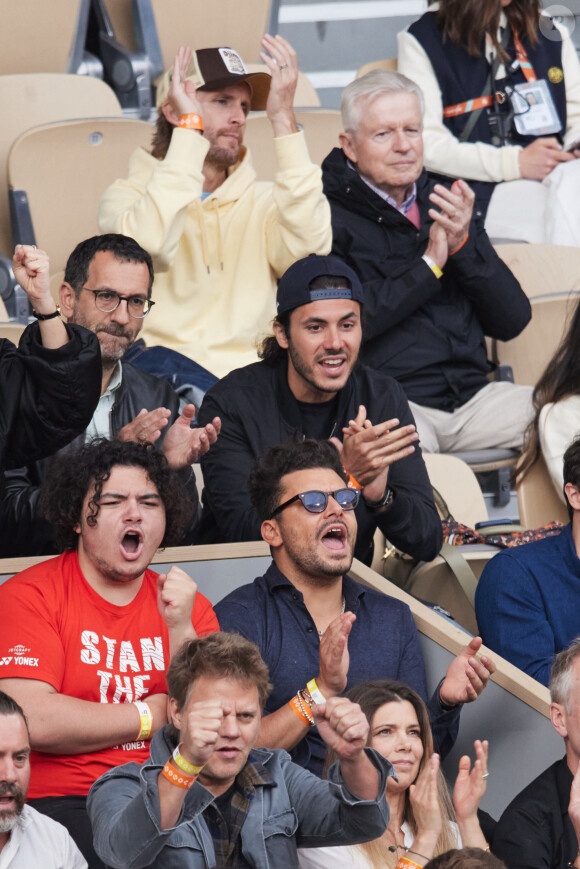 Kev Adams et son frère Lirone, Philippe Lacheau et son père Gérard Lacheau - Célébrités dans les tribunes des Internationaux de France de tennis de Roland Garros 2024 à Paris le 26 mai 2024. © Moreau-Jacovides/Bestimage 