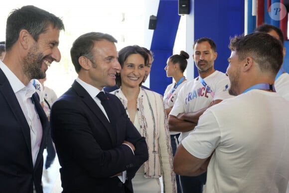 Le président français Emmanuel Macron, deuxième à gauche, s'entretient avec les membres de l'équipe de France avec Tony Estanguet, à gauche, président du comité d'organisation des Jeux Olympiques et Paralympiques de Paris 2024 et la ministre française des Sports et des Jeux olympiques Amélie Oudea-Castera, au centre, lors de sa visite aux Jeux olympiques Village le lundi 22 juillet 2024, à Paris, France. © Michel Euler/Pool/Bestimage