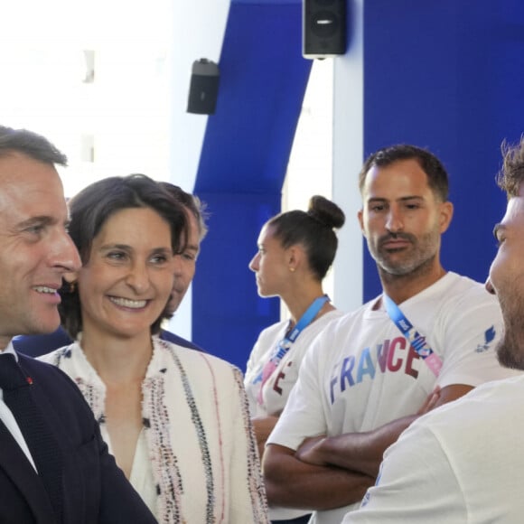 Le président français Emmanuel Macron, deuxième à gauche, s'entretient avec les membres de l'équipe de France avec Tony Estanguet, à gauche, président du comité d'organisation des Jeux Olympiques et Paralympiques de Paris 2024 et la ministre française des Sports et des Jeux olympiques Amélie Oudea-Castera, au centre, lors de sa visite aux Jeux olympiques Village le lundi 22 juillet 2024, à Paris, France. © Michel Euler/Pool/Bestimage