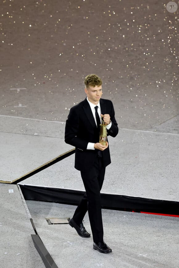 Léon Marchand s'apprête à remettre la flamme olympique à T.Bach, président du CIO, sous le regard de T.Riner et d'autres athlètes - Cérémonie de clôture des Jeux Olympiques de Paris 2024 au stade de France à Saint-Denis, le 11 août 2024. © Jacovides-Perusseau / Bestimage