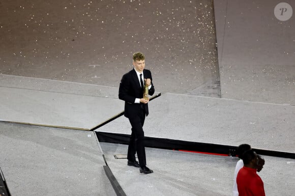 Léon Marchand s'apprête à remettre la flamme olympique à T.Bach, président du CIO, sous le regard de T.Riner et d'autres athlètes - Cérémonie de clôture des Jeux Olympiques de Paris 2024 au stade de France à Saint-Denis, le 11 août 2024. © Jacovides-Perusseau / Bestimage