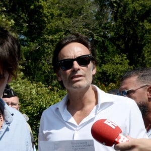 Anthony Delon et son demi-frère Alain-Fabien découvrent les hommages devant les grilles de la propriété de Douchy, quelques heures avant les obsèques de leur père, A.Delon, le 24 août 2024.