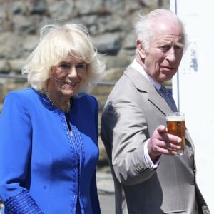 Lorsqu'il s'est retiré de la sphère publique pour se focaliser sur sa santé, Camilla Parker Bowles a honoré grand nombre de ses engagements officiels. 
Le roi Charles III d'Angleterre et la reine Camilla (Camilla Parker Bowles, reine consort d'Angleterre) visitent Guernesey le mardi 16 juillet 2024, Charles déguste une bière appelée Charles Golden Ale © Ian Vogler/MirrorPix/bestimage