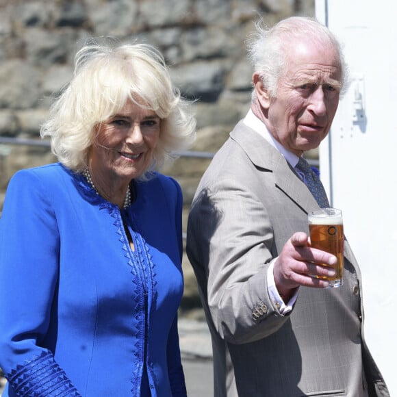 Lorsqu'il s'est retiré de la sphère publique pour se focaliser sur sa santé, Camilla Parker Bowles a honoré grand nombre de ses engagements officiels. 
Le roi Charles III d'Angleterre et la reine Camilla (Camilla Parker Bowles, reine consort d'Angleterre) visitent Guernesey le mardi 16 juillet 2024, Charles déguste une bière appelée Charles Golden Ale © Ian Vogler/MirrorPix/bestimage