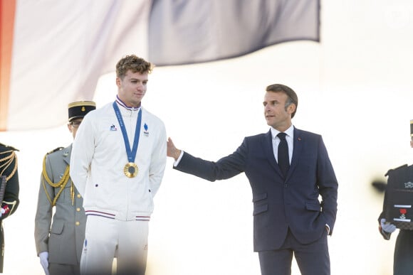 Léon Marchand, Emmanuel Macron - Remise des médailles par le président de la République à l'Arc de Triomphe aux athlètes lors de la parade des champions à l'occasion des Jeux Olympiques et Paralympiques Paris 2024, sur l'avenue des Champs-Elysées à Paris. Le 14 septembre 2024 © Perusseau-Ramsamy / Bestimage 