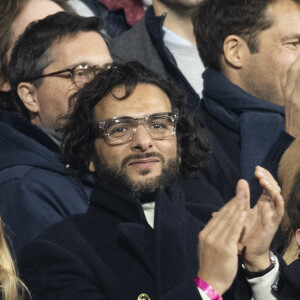 Maxim Nucci (Yodelice) et sa compagne Isabelle Ithurburu dans les tribunes lors du match de rugby du Tournoi des 6 Nations opposant la France à l'Angleterre au stade de France, à Saint-Denis, Seine Saint-Denis, France, le 19 mars 2022. La France s'offre le grand chelem dans le Tournoi des six nations, après sa victoire 25-13 contre l'Angleterre. © Cyril Moreau/Bestimage 