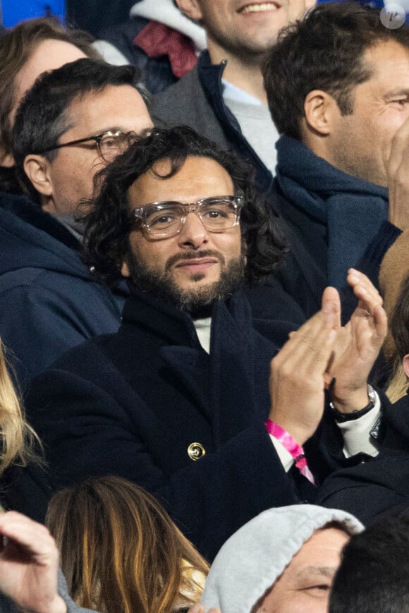 Maxim Nucci (Yodelice) et sa compagne Isabelle Ithurburu dans les tribunes lors du match de rugby du Tournoi des 6 Nations opposant la France à l'Angleterre au stade de France, à Saint-Denis, Seine Saint-Denis, France, le 19 mars 2022. La France s'offre le grand chelem dans le Tournoi des six nations, après sa victoire 25-13 contre l'Angleterre. © Cyril Moreau/Bestimage 