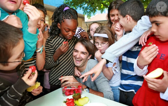 Le chef cuisinier Cyril Lignac est entouré d'écoliers lors du lancement de la campagne "Un fruit à la récré" visant à inciter les enfants à manger plus de fruits, dans une école de Bordeaux, dans le sud-ouest de la France, le 6 mai 2008. Photo par Patrick Bernard/ABACAPRESS.COM