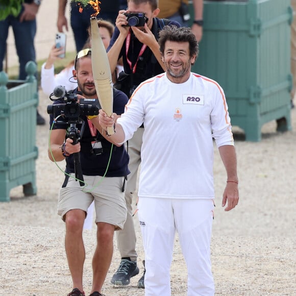 Le chanteur et acteur Patrick Bruel porteur de la flamme olympique des Jeux Olympiques de Paris 2024 (JO) au château de Versailles dans les Yvelines, France, le 23 juillet 2024. © Dominique Jacovides/Bestimage