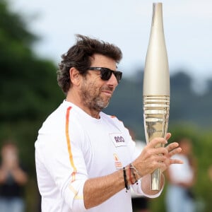 Le chanteur et acteur Patrick Bruel porteur de la flamme olympique des Jeux Olympiques de Paris 2024 (JO) au château de Versailles dans les Yvelines, France, le 23 juillet 2024. © Dominique Jacovides/Bestimage