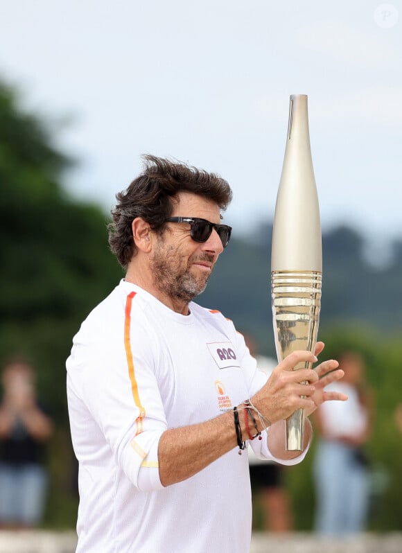 Le chanteur et acteur Patrick Bruel porteur de la flamme olympique des Jeux Olympiques de Paris 2024 (JO) au château de Versailles dans les Yvelines, France, le 23 juillet 2024. © Dominique Jacovides/Bestimage