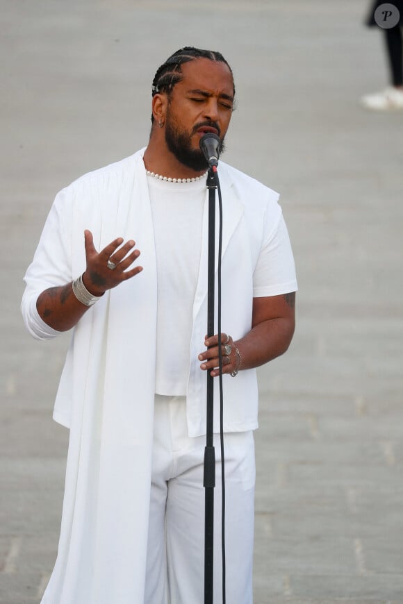 Exclusif - Slimane interprète sa nouvelle chanson "Résister" sur le parvis de Notre-Dame à Paris. Le 6 juin 2024. A quelques jours de la sortie de ce nouveau single, le chanteur a fait un happening étonnant hier soir à 20h30 entouré de 30 choristes. Ces images tournées intégreront le clip qui, lui aussi, sortira prochainement. © Christophe Clovis / Bestimage