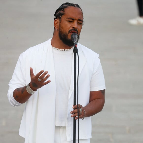 Exclusif - Slimane interprète sa nouvelle chanson "Résister" sur le parvis de Notre-Dame à Paris. Le 6 juin 2024. A quelques jours de la sortie de ce nouveau single, le chanteur a fait un happening étonnant hier soir à 20h30 entouré de 30 choristes. Ces images tournées intégreront le clip qui, lui aussi, sortira prochainement. © Christophe Clovis / Bestimage