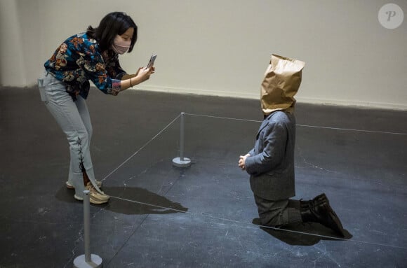 Une oeuvre de Maurizio Cattelan représentant un homme à genoux avec un sac en papier sur la tête au UCCA Center for Contemporary Art in Beijing, en Chine le 5 décembre 2021.