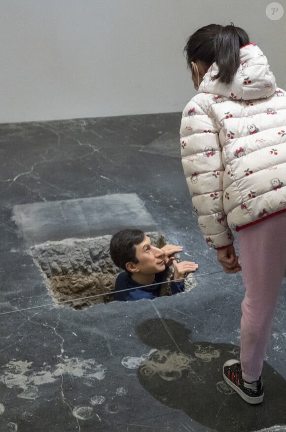 Une oeuvre de Maurizio Cattelan qui représente un homme regardant en dehors d'un tunnel au UCCA Center for Contemporary Art in Beijing, en Chine, le 5 décembre 2021.