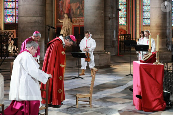 Le recteur de la cathédrale Notre-Dame de Paris, Patrick Chauvet, l'évêque auxiliaire de Paris, Denis Jachiet, l'archevêque de Paris, Michel Aupetit, le violoniste Renaud Capuco assistent à une cérémonie de méditation pour célébrer le Vendredi saint dans une partie sécurisée de la cathédrale Notre-Dame de Paris, le 10 avril 2020, à Paris. Photo par Ludovic Marin/Pool/ABACAPRESS.COM)