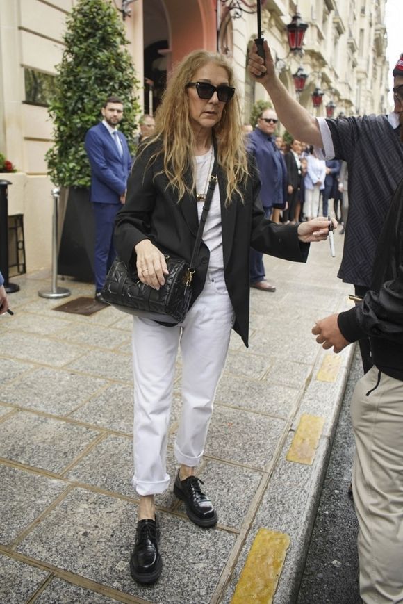 Paris, FRANCE - Canadian singer Celine Dion leaves her hotel for the airport, taking time to greet and sign autographs for the crowd of fans waiting for her, showing her appreciation for their support. Pictured: Celine Dion