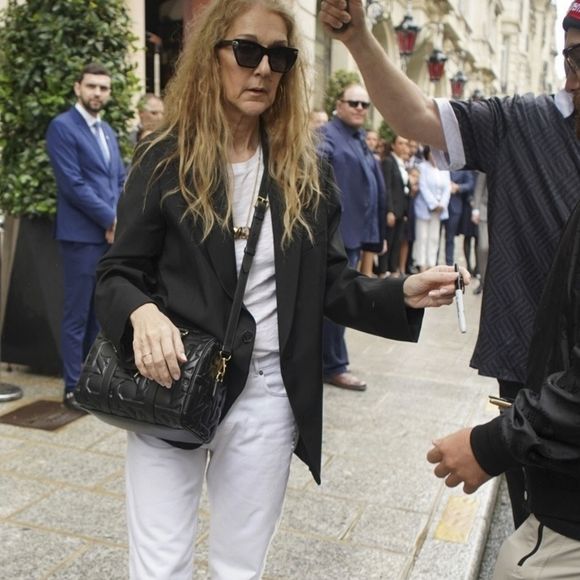 Paris, FRANCE - Canadian singer Celine Dion leaves her hotel for the airport, taking time to greet and sign autographs for the crowd of fans waiting for her, showing her appreciation for their support. Pictured: Celine Dion