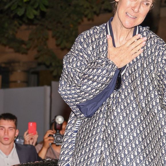 Paris, FRANCE - Celine Dion in full Dior creates a crowd movement as she exits through the roof of her car leaving her hotel in Paris followed by her fans Pictured: Celine Dion