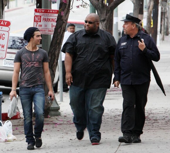 De retour de vacances, Joe Jonas se rend à une séance photo en compagnie de son garde du corps, à Hollywood, le samedi 10 avril.
