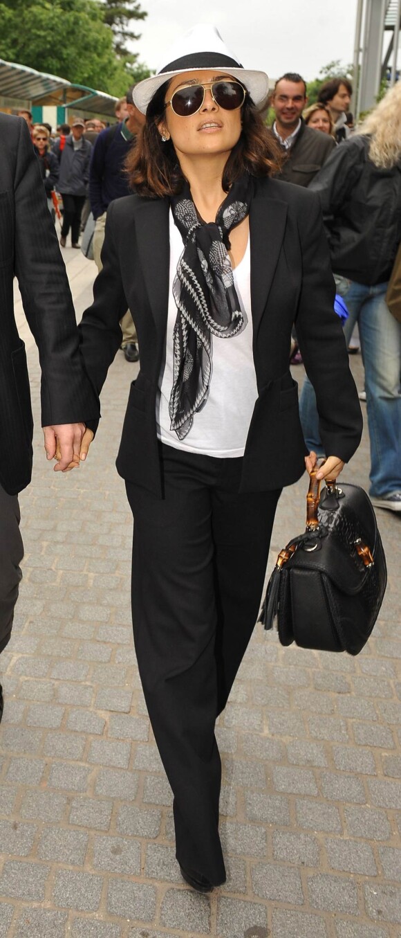Tailleur divinement coupé, petit t-shirt blanc, foulard joliment noué, et chapeautée d'un borsalino, Salma Hayek est au top !