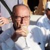 Jacques Chirac se détend sur le port de Saint-Tropez avec un bon verre et une foule de badauds qui viennent le saluer le 5 août 2010