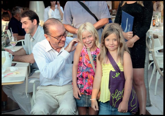 Jacques Chirac se détend sur le port de Saint-Tropez avec un bon verre et une foule de badauds qui viennent le saluer le 5 août 2010