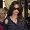 Kim Kardashian très "babydoll" dans une jupette ceinturée, portée avec un chemisier noir et des escarpins Cesare Paciotti.