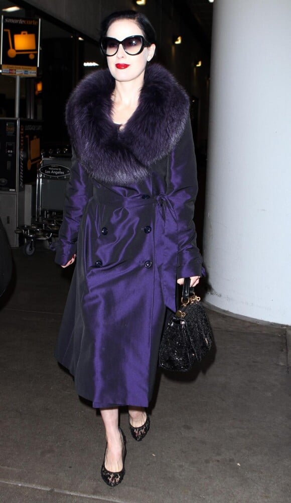 La reine du rétro  n'hésite pas à porter un manteau violet avec un col en fourrure.