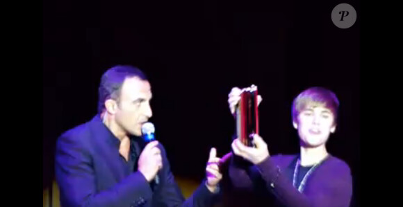 Justin Bieber reçoit le NRJ Music Award de la Révélation internationale de l'année des mains de Nikos Aliagas, lors de sa venue au Grand Rex (Paris), le jeudi 17 février.