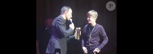 Justin Bieber reçoit le NRJ Music Award de la Révélation internationale de l'année des mains de Nikos Aliagas, lors de sa venue au Grand Rex (Paris), le jeudi 17 février.