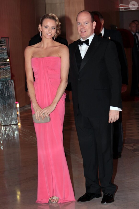Charlene Wittstock brille en longue robe bustier colorée et prend quelques risques en portant un vieux rose au bras de son compagnon. En mai 2010