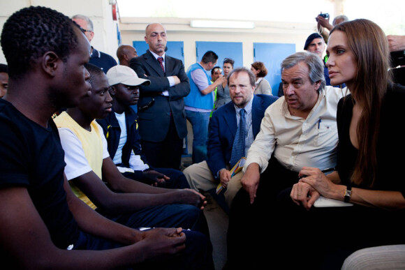 Le Haut-commissaire aux réfugiés pour les Nations Unies,  Antonio Guterres, et l'ambassadrice Angelina Jolie parlent avec des demandeurs d'asile à Lampedusa (Italie) le 19 juin 2011