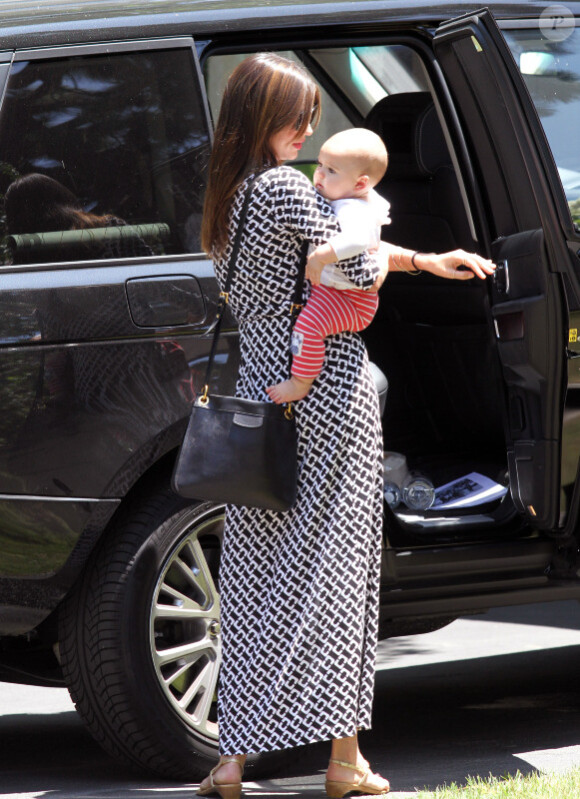 Miranda Kerr ne lâche pas une seule seconde son beau bébé des yeux, même pour sortir de sa voiture alors qu'elle rend visite à une amie à Santa Barbara le 23 juillet 2011